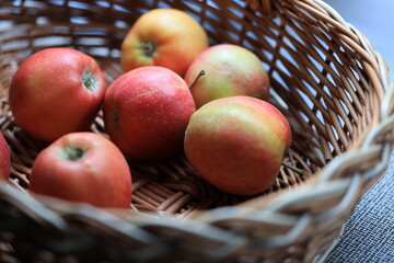 A colorful basket filled with many red and green apples.