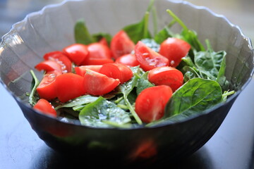 Fresh spinach and tomatoes served on a table.