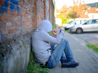 portrait of handcuffed man with face hidden by sweatshirt hood