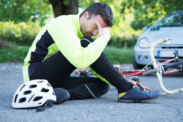 aching man after bicycle accident on the asphalt