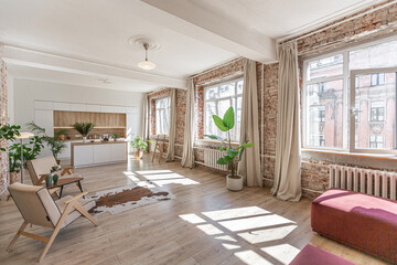 Bright and spacious living area featuring modern furniture and natural light in a stylish apartment in soft warm colors