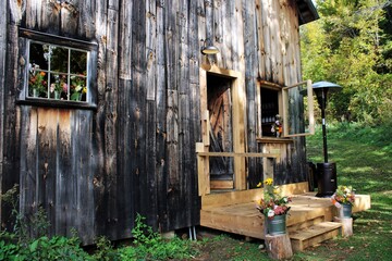 Rustic Wooden Barn Entrance with Porch and Flowers

