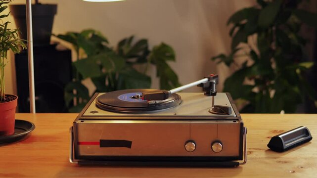 Retro Vinyl record player playing music, close-up macro shot of vintage LP disc old phonograph spinning. Retro music player at home.