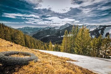 Ein typisches winterliches Alpenpanorama mit einer Rolle Stacheldraht