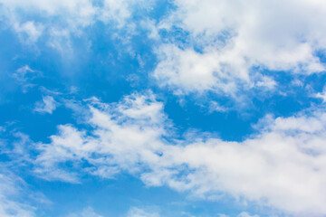 Obraz premium Serene blue sky with scattered white clouds for nature background or atmospheric wallpaper