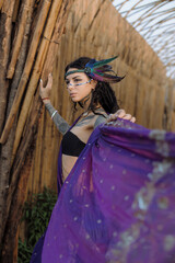 a woman in a purple dress is standing in front of a wooden wall