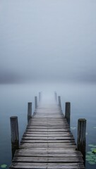 Obraz premium A serene wooden dock stretches into a thick fog, creating a tranquil atmosphere that invites reflection and calmness.