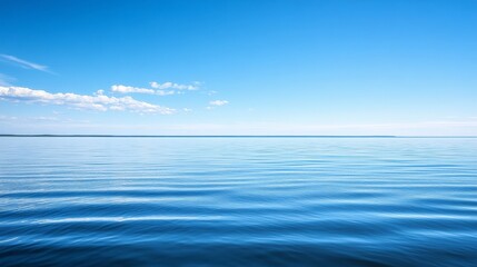Obraz premium A tranquil view of calm water reflecting a clear blue sky, evoking serenity and peace.