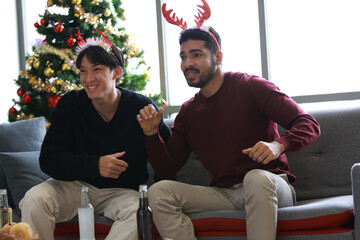 Two young males Watching Sports Match During Christmas Party
