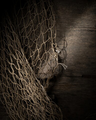 Empty fishing net on wooden table, fishing industry concept, space for text
