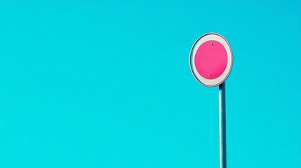 A minimalist image of a pink circular sign against a bright turquoise sky.
