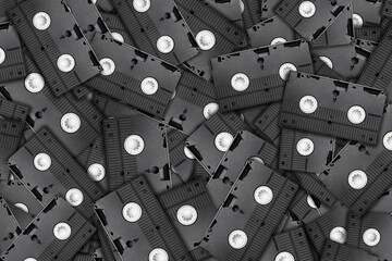 Black VHS tapes stacked in a group background. Textured pattern showcasing outdated technology....