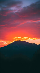 Fototapeta premium A silhouette of a mountain range against a vibrant sunset sky.
