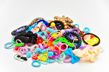 Different types and color of elastic bands, pins, clips and ties for hair on white background.