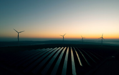 Windmill turbines generating green energy electric.Solar panels park and wind turbines at...