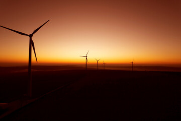 Obraz premium Windmill turbines generating green energy electric.Green energy helps reduce carbon emissions and makes earth cleaner and more ecological.