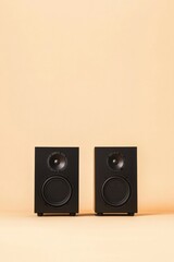 modern black audio speakers on a warm-toned background