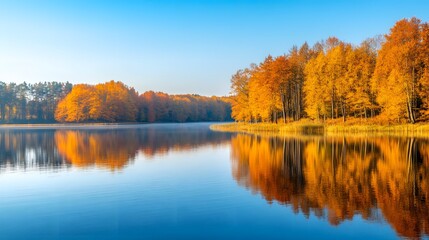 Obraz premium A picturesque lake surrounded by autumn trees, their vibrant colors perfectly mirrored in the calm, reflective water
