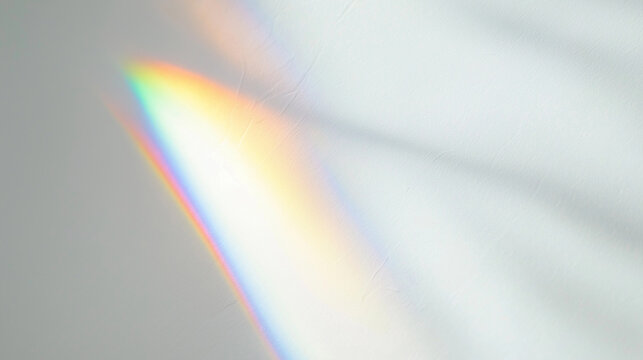 Soft blurred rainbow light refraction texture overlay effect for mockups. Shadows for natural light effects. Organic holographic flare on a white wall. Copy space, background.