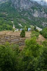 Church of Santa Eulalia de Unha with the Unha peak in the background. The town is located in the Aran valley, near Baqueira. Pyrenees Mountains, Spain