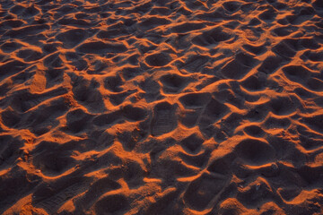 Close-up of sand with footprints at sunset