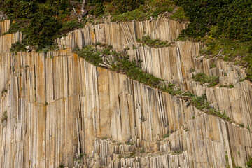Rocks of Stolbchaty. landscape with columnar basalt lavas rocks forming a natural geometric pattern. Geographic cape on the east shore of Kunashir Island of Sakhalin Oblast, Russia. Mendeleyev volcano