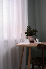 A Cozy Tea Setup featuring a Candle and Greenery beautifully arranged on a Table