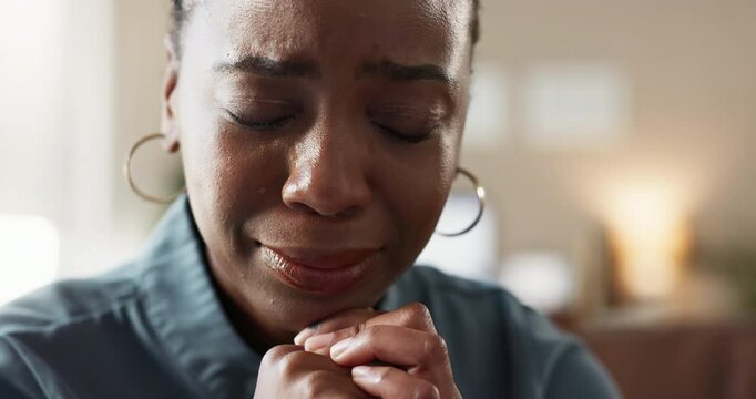 Black woman, anxiety and crying on sofa in home for bad news, depression and broken heart problem. Female person, sad and wiping tissue in living room for pain, trauma and overwhelmed with emotions