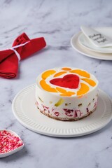 Jelly cake with red heart center on white plate on light marble background. Valentine's Day desserts. Valentine's Day.
