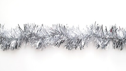 Silver tinsel on white background, festive holiday decoration.