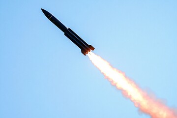 Rocket launch under clear blue sky with vibrant flames emanating from the engine during a test flight in an open area