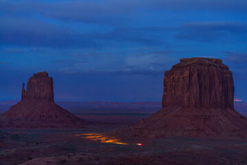 Car driving through Monument Valley desert landscape after dusk