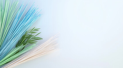 Fototapeta premium Vibrant colored straws in blue, green, and white arranged with green leaves create fresh and lively composition. Perfect for creative projects or decorations