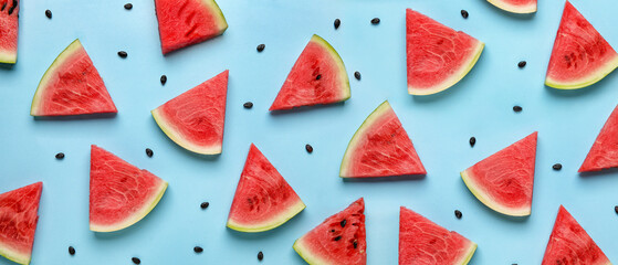 Slices of tasty watermelon with seeds on blue background