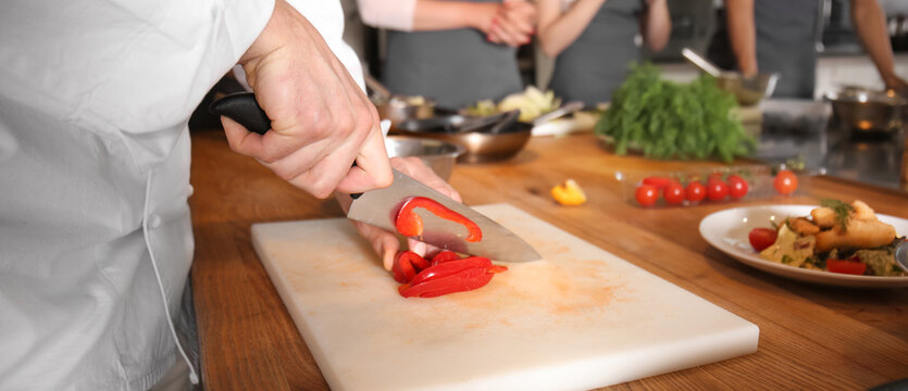 Male chef cutting vegetables during cooking classes