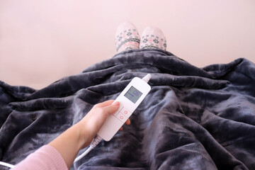 Electric blanket. Woman adjusting temperature on electric blanket. 