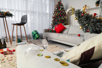 Broken glass with confetti on sofa in messy living room after New Year party, closeup
