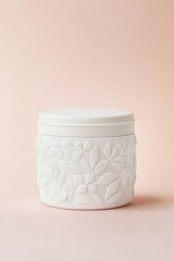 Elegant white ceramic jar with floral embossed design on a soft pink background