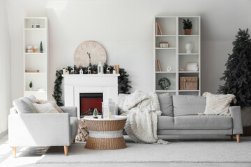 Sofas, coffee table with lantern, fireplace, shelving unit and Christmas tree in interior of living room