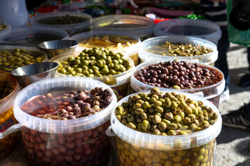 Large Containers of Colorful Olive Varieties at Market Stand