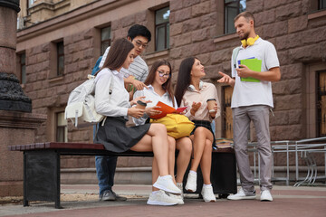 Fototapeta premium Group of students with backpacks and copybooks near university