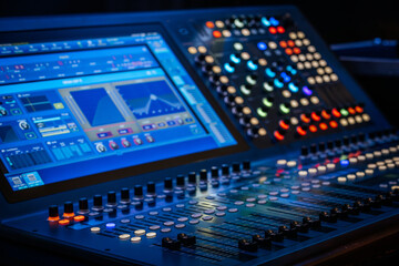 Close-up view of a digital audio mixing console featuring an interactive display and colorful LED-lit knobs. Ideal for sound engineering, music production, and live performance settings