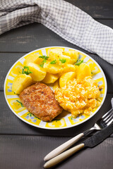 Minced pork cutlet served with potatoes and sauerkraut salad.