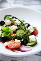Healthy Salad with Feta Cheese, Black Olives, Cucumber and Cherry Tomatoes. Bright background. Close up.