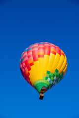 Vibrant Kubicek Hot Air Balloon Soaring in Clear Blue Sky