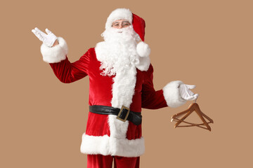 Santa Claus with wooden hangers on brown background
