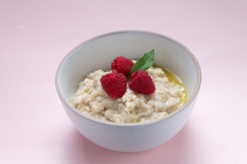 oatmeal with butter and raspberries in a white plate, healthy breakfast