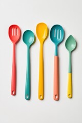 Colorful kitchen utensils arranged on a white background