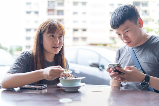 June 2024. A Chinese-Malaysian couple in their 30s chat while eating chendol at a local restaurant in Kuala Lumpur, Malaysia.