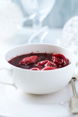 Traditional Christmas Borscht (Barszcz) with mushroom dumplings on bright background.
